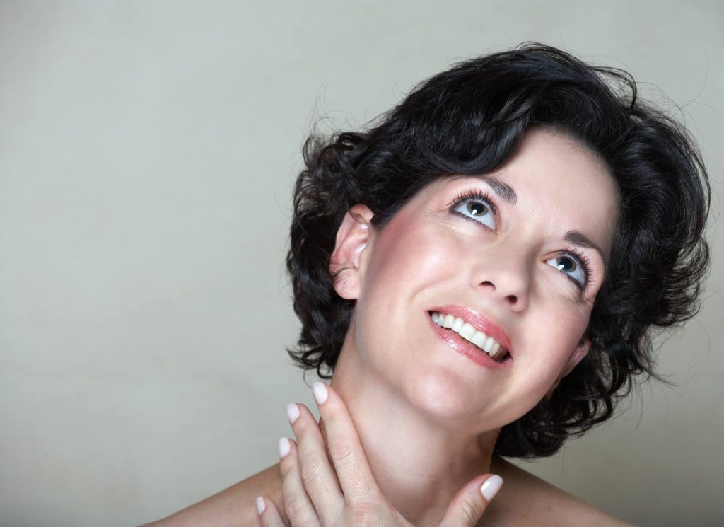 tiroide: una donna si tocca il collo